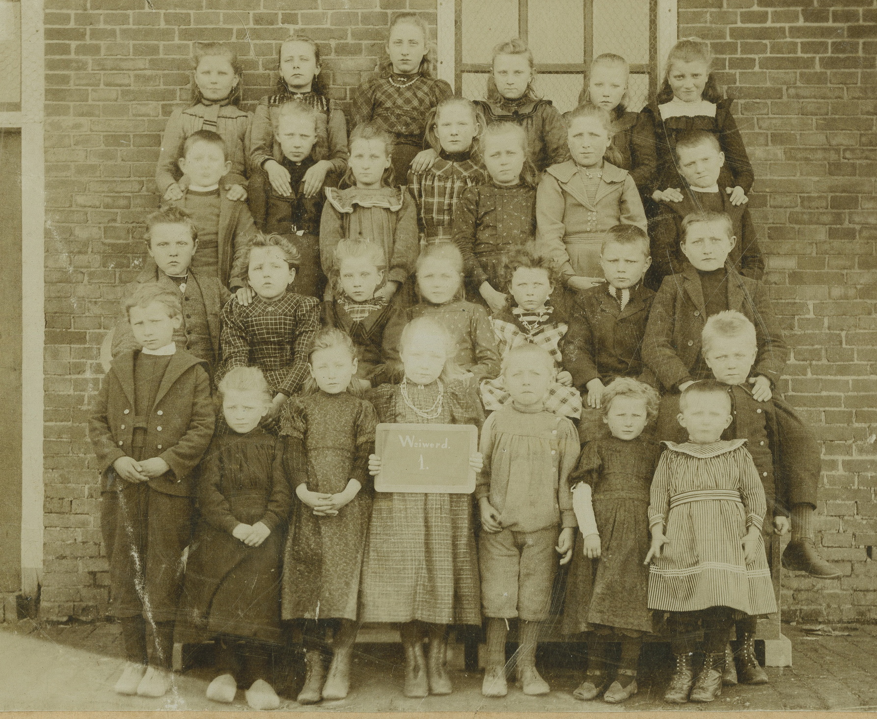 Lagere school: klassenfoto eerste klas : met o.a. Annechien Jantina Keijer (2e rij v.b. 2e v.r.) en Fennechien Auwina Keijer (3e rij v.b.3e v.r.). Vervaardiger: S. Sanders & Zn., 1902-1904. 