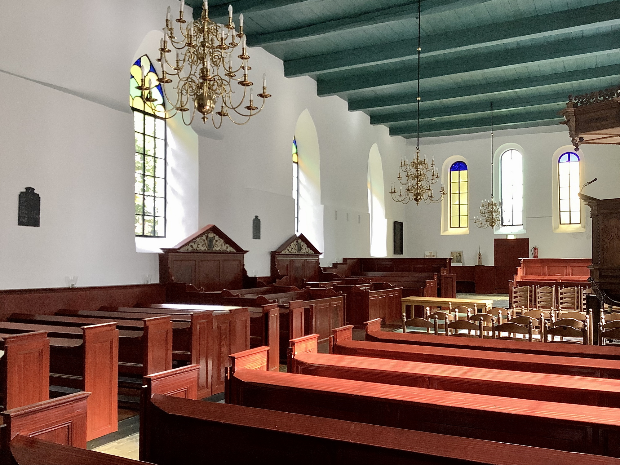 Interieur naar het oosten, met rechts de preekstoel en links de twee herenbanken. Een deel van de kerk heeft nog de oorspronkelijke zitbanken. Foto: ©Jur Kuipers.