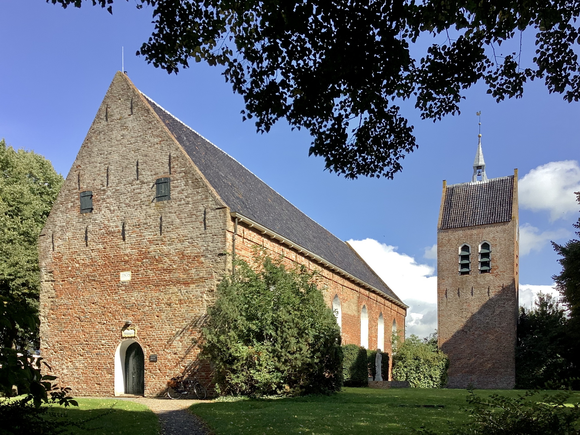 De kerk gezien vanuit het zuidwesten met rechts de losstaande toren. Foto: ©Jur Kuipers.