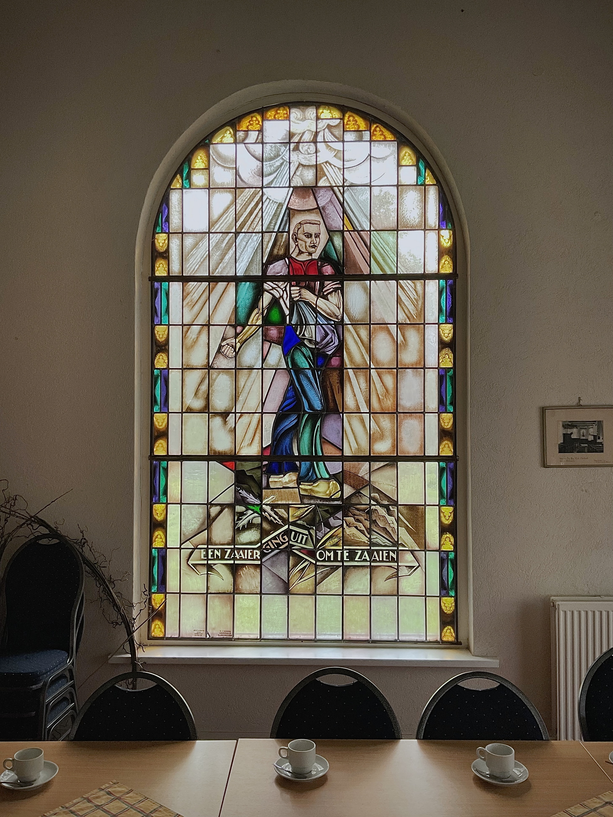 'Een zaaier ging uit om te zaaien', glas-in-loodraam in het gebouwtje naast de kerk. Foto: ©Jur Kuipers.