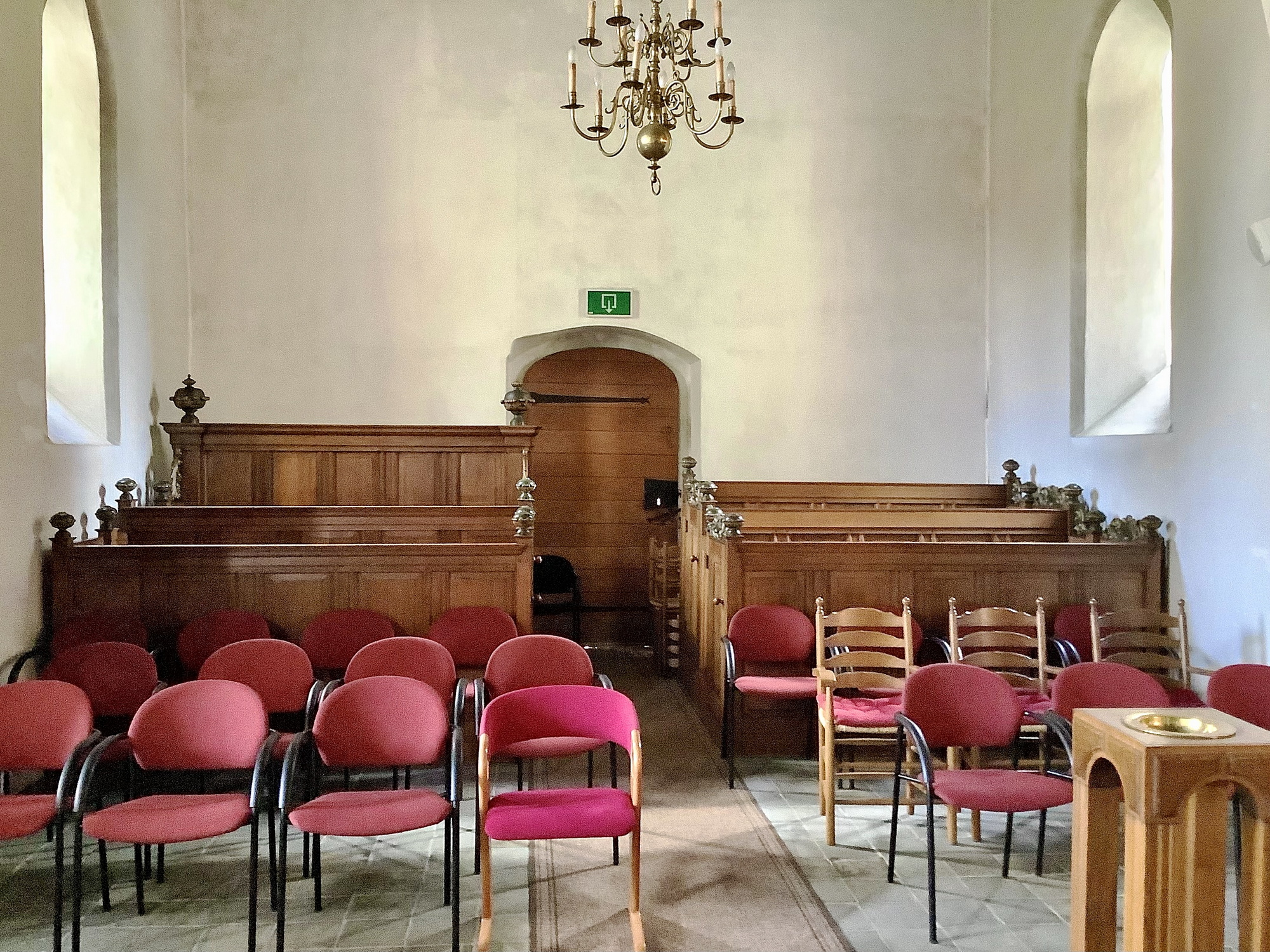 Banken met paneelwerk (18e eeuw) en stoelen in de uitbouw aan de zuidkant van de kerk. Foto: ©Jur Kuipers.