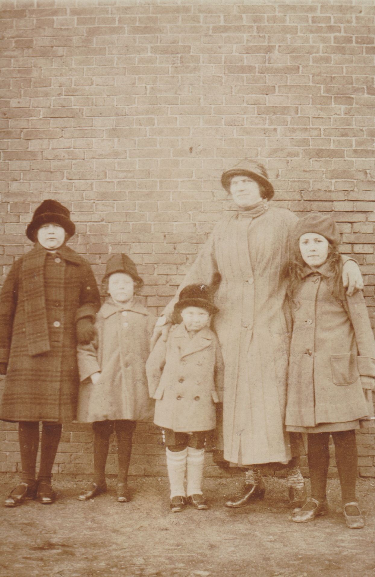 Foto links: Achter op de foto staat de volgende tekst: Febr. 1925, v.l.n.r. Ida, Harmannus,

Henkie, de Duitse hulp Mina van de dokter Marianne Eelkema.