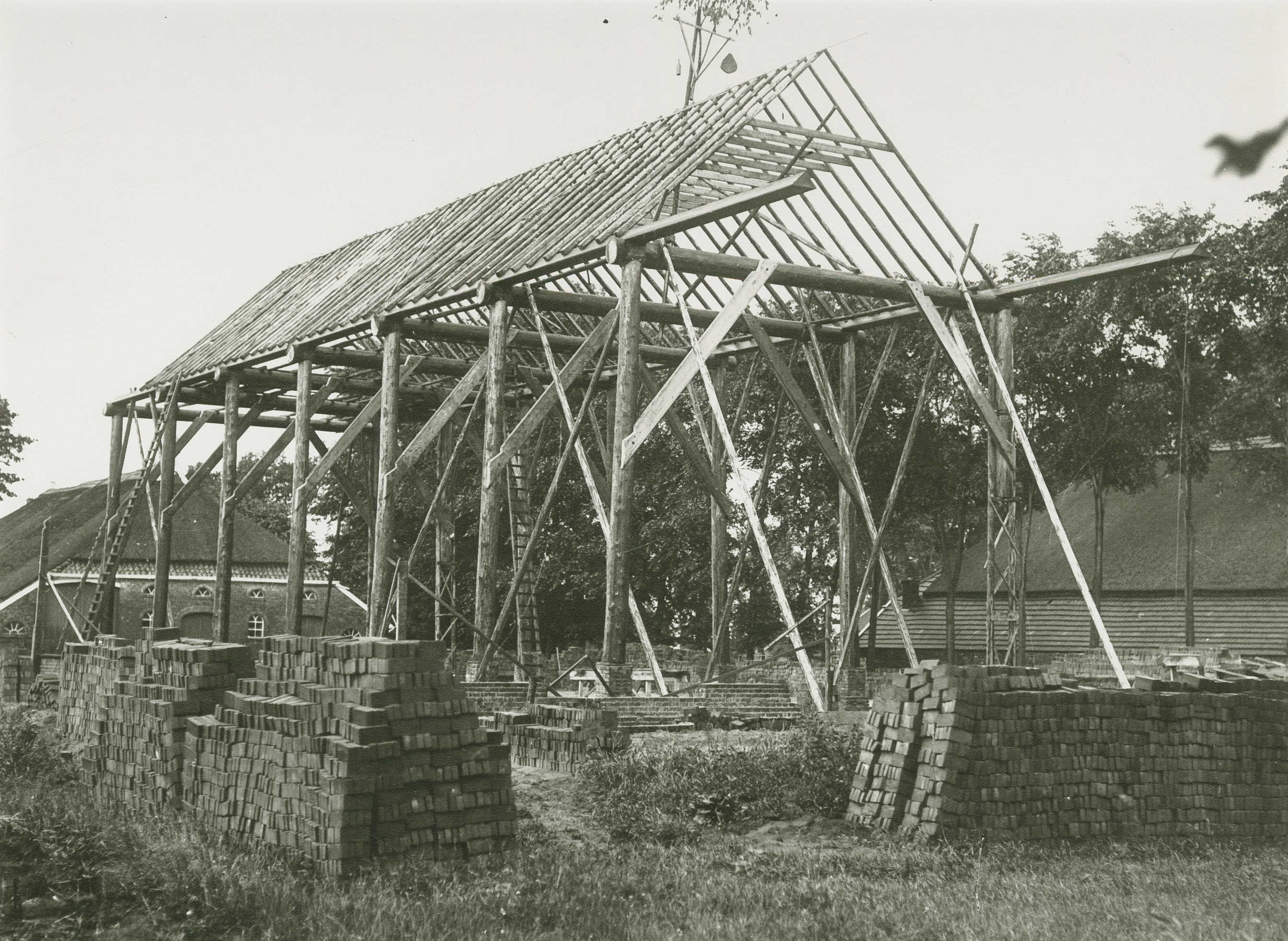 Schildwolde: boerenschuur in aanbouw. Boven de gereedgekomen nok van de toekomstige schuur is de zogenaamde meiboom te zien. Foto: Collectie Kramer, 1915-1940. Uit deze foto blijkt dat het gebruik van de meiboom in de eerste helft van de 20e-eeuw ook nog in gebruik is. Bron: RHCGA, Groninger Archieven, Beeldbank Groningen. Licentie: Creative Commons.